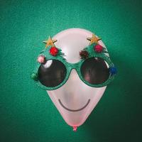 óculos de natal que decoração com árvore de natal no balão de ar sobre fundo verde foto
