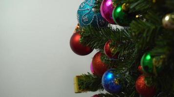 conceito de temporada de saudação configuração manual de enfeites em uma árvore de natal com luz decorativa foto