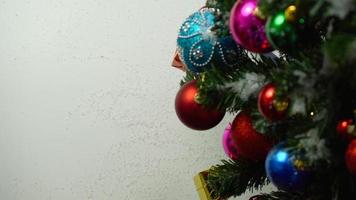 conceito de temporada de saudação configuração manual de enfeites em uma árvore de natal com luz decorativa foto