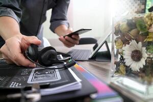 homem usando fone de ouvido voip com teclado de encaixe de computador tablet digital, telefone inteligente, comunicação de conceito, suporte, call center e suporte ao cliente, flores de vaso na mesa de madeira foto