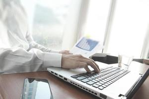 mão de homem de negócios trabalhando no computador portátil na mesa de madeira como conceito foto