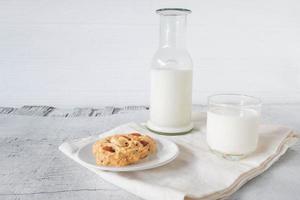 biscoitos e leite em fundo branco de madeira foto