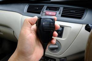 mão segurando microfone walkie-talkie comunicação de rádio no carro foto