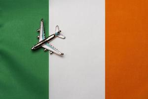 avião sobre a bandeira do conceito de viagens da irlanda. avião de brinquedo em uma bandeira. foto
