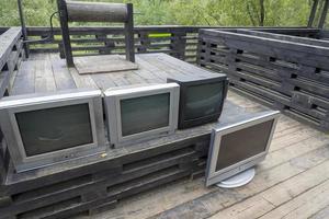 muitas tvs antigas em uma mesa de madeira. foto