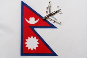 avião sobre a bandeira do nepal o conceito de ilha de viagens e turismo. foto