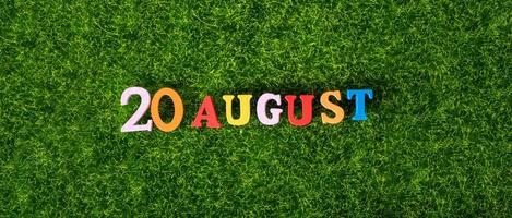 20 de agosto. imagem de letras coloridas de madeira e números em 20 de agosto no contexto de um gramado verde. foto