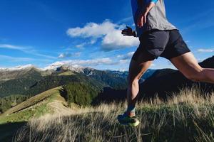 detalhe das pernas do corredor de montanha durante um treino em declive foto