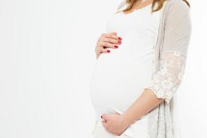 mulher grávida segura as mãos na barriga em um fundo branco. conceito de gravidez, maternidade, preparação e expectativa. linda foto de humor terno da gravidez.