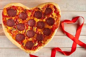 pizza de calabresa em forma de coração em fundo de madeira. presente de dia dos namorados. foto