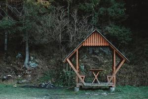 gazebo de madeira no gramado em um fundo de floresta e montanhas. copiar, espaço vazio para texto foto