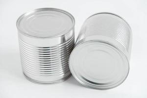 duas latas de metal fechadas de alumínio em uma mesa branca. copiar, espaço vazio para texto foto