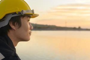 um engenheiro masculino usando um capacete protetor ao pôr do sol. foto