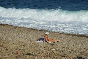 vladivostok, rússia-23 de julho de 2019- paisagem marinha com uma mulher solitária tomando sol em uma costa rochosa. foto