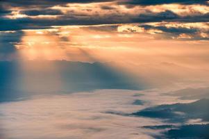 raio de sol brilhando nublado sobre a montanha doi luang chiang dao e nevoeiro pela manhã foto