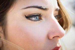 close-up dos olhos azuis da jovem com cílios longos foto