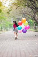 crianças felizes menina pano vermelho sorriso e correndo com balões coloridos foto