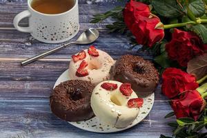 rosquinhas artesanais em um fundo claro em chocolate branco e preto. há flores nas proximidades. dia da mulher, dia dos namorados. foto