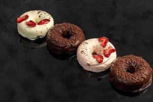 rosquinhas artesanais em um fundo claro em chocolate branco e preto. há flores nas proximidades. dia da mulher, dia dos namorados. foto