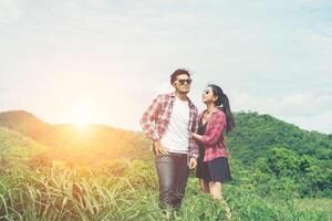 casal jovem hippie de mãos dadas andando no Prado atmosfera relaxante e natural é muito natural. foto