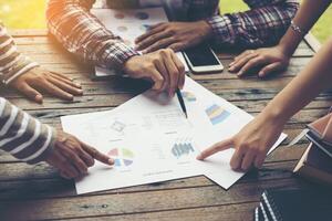 análise de equipe de negócios jovem com gráfico financeiro no escritório, local de trabalho, horários ocupados. foto