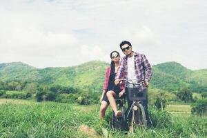 casal jovem hippie de mãos dadas andando no Prado atmosfera relaxante e natural é muito natural. foto