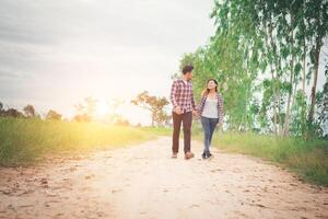 casal jovem hippie andando na estrada rural curtindo com a natureza, amor casal, viagens de férias, passar tempo juntos. foto