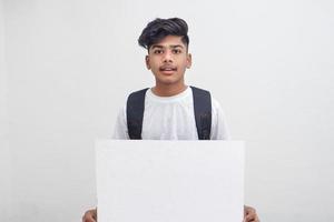 estudante universitário indiano apresentando placa em fundo branco. foto