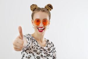 rosto de mulher de close-up. moda feminina closeup em roupas da moda, isoladas no fundo branco. diversão de verão e acessórios de verão. garota engraçada. grande polegar para cima. foco seletivo foto