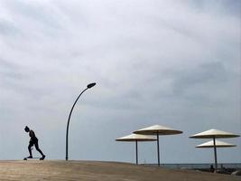 espreguiçadeira elegante na areia amarela para tomar sol na praia foto