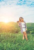 mulher jovem hippie com câmera retrô, tirando um tiro na paisagem ao ar livre, natureza de montanha de estilo de vida no fundo. foto