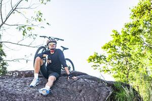 atletas sentados na montanha com bicicleta foto