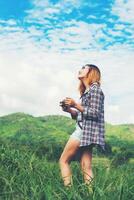 mulher jovem hippie com câmera retrô, tirando um tiro na paisagem ao ar livre, natureza de montanha de estilo de vida no fundo. foto