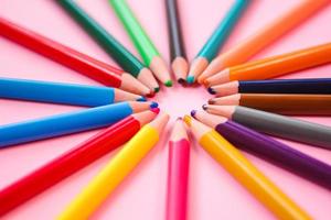 lápis multicolorido no fundo rosa foto