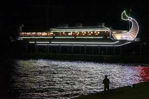 yalta, crimeia-17 de outubro de 2017 - paisagem noturna com iluminação brilhante do edifício e reflexo no mar foto