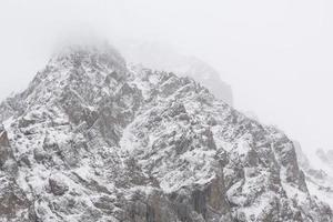 paisagem de montanhas rochosas de inverno com nevoeiro foto