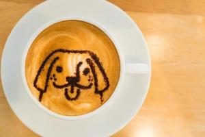 uma xícara de café com leite quente na mesa de madeira foto