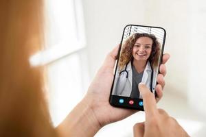 paciente fazendo videochamada com médico online via celular, serviço de consulta médica domiciliar e conceitos de telessaúde foto