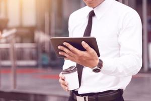 hora da manhã do jovem economista confiante segurando o tablet digital lendo e-mail ou procurando marketing de ações. foto