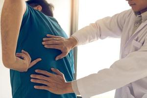 paciente está apontando para o ponto onde a dor muscular é fornecida ao fisioterapeuta para verificar. foto