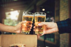 amigos de adolescente brindando e brindando com um copo de cerveja. foto