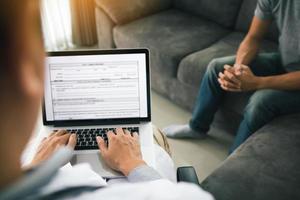 médico está usando um laptop enquanto digita o registro do histórico pessoal do paciente e dá conselhos sobre o tratamento domiciliar do paciente. foto