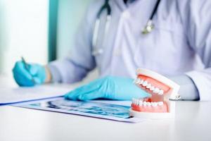 os dentistas estão anotando os detalhes do paciente na sala do escritório. foto