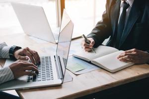 equipe de dois empresários calcula sobre o relatório resumido anual no escritório de mesa. foto