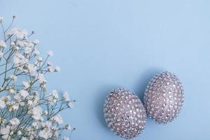 ovos de páscoa glamourosos com flores. decorações de mesa alegres para o feriado da primavera. conceito mínimo de moda foto
