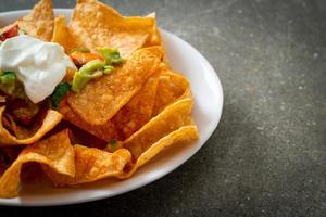 chips de tortilha de nachos com jalapeño, guacamole, molho de tomate e molho foto