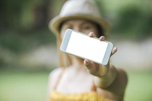 mão de uma mulher segurando um celular, smartphone com tela branca foto