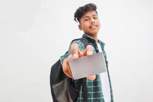 jovem indiano mostrando cartão de débito ou crédito em fundo branco. foto