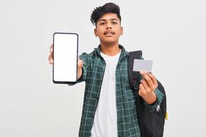 estudante universitário indiano mostrando a tela do celular e cartão em fundo branco. foto