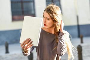 jovem mulher olhando para tablet foto